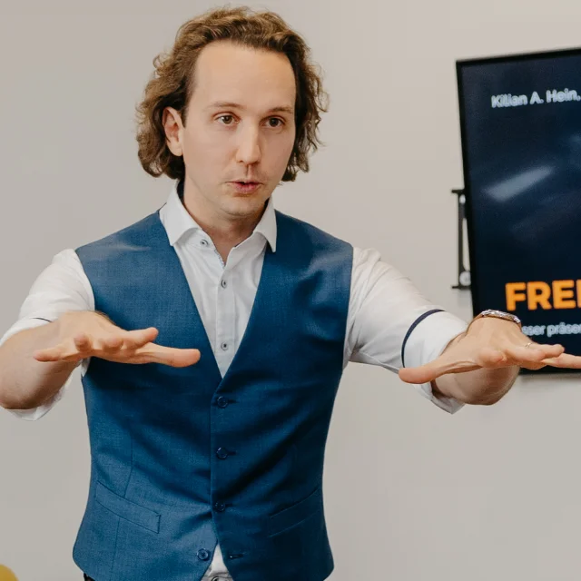 ein mann mit locken und ausgestreckten armen vor dem koerper