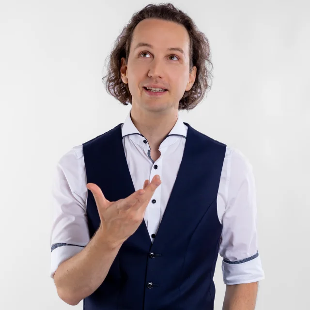 ein mann mit langen locken und weste schaut nachdenklich nach oben